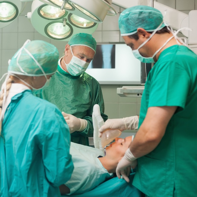 Ärzte im OP Saal betäuben Patienten